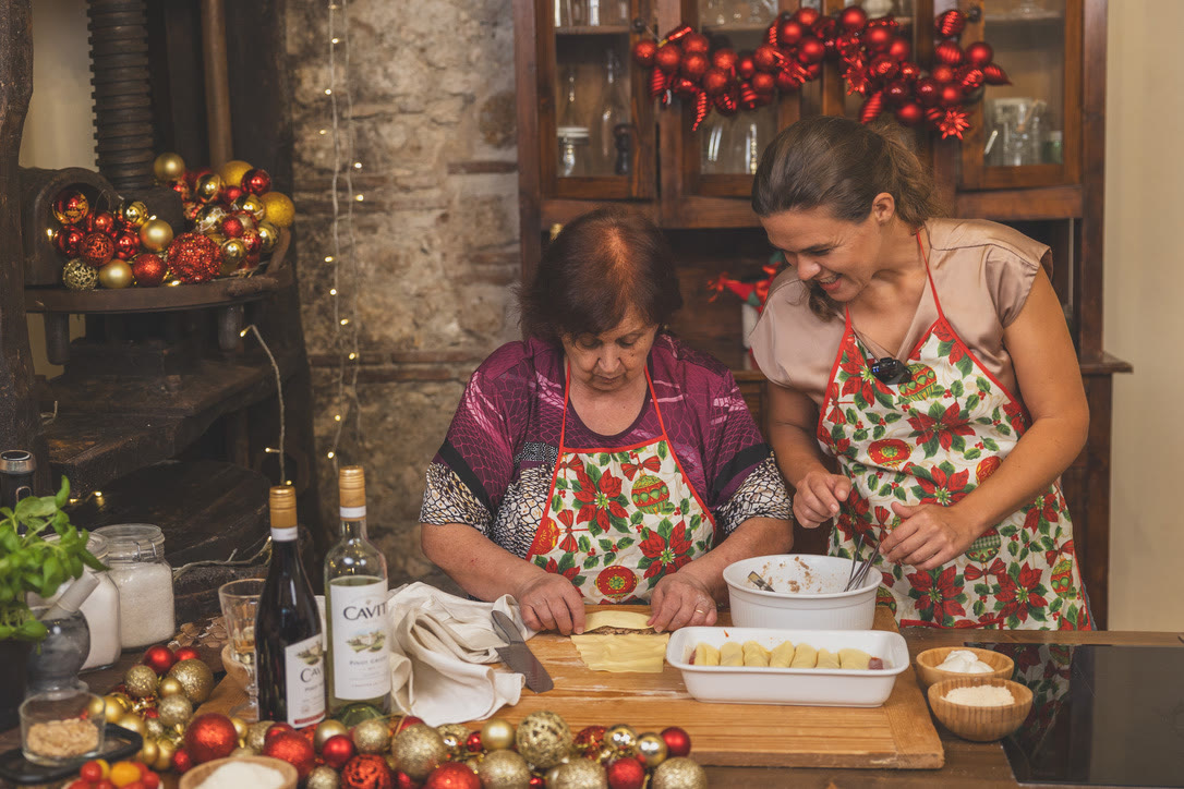 Nonna rolls ragù filling into pasta sheets and lines the cannelloni up in a baking dish.